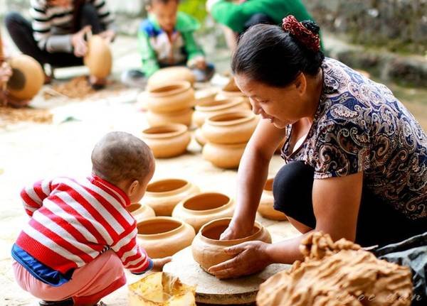 Người phụ nữ nặn nồi đất cùng em bé